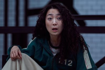 Kim Joo-ryung as Han Mi-nyeo, or player 212, looking shocked in a bunk in squid game season 1