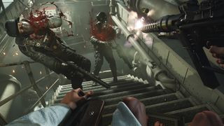 Wolfenstein 2 screenshot of the player character gunning down two enemies on a staircase