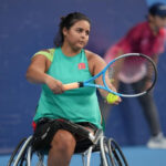 Female wheelchair tennis athlete Najwa Awane prepped to serve at the Tokyo 2020 Paralympic Games, demonstrating focus and athleticism