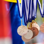 Ancient Olympic medals hang against blurry background