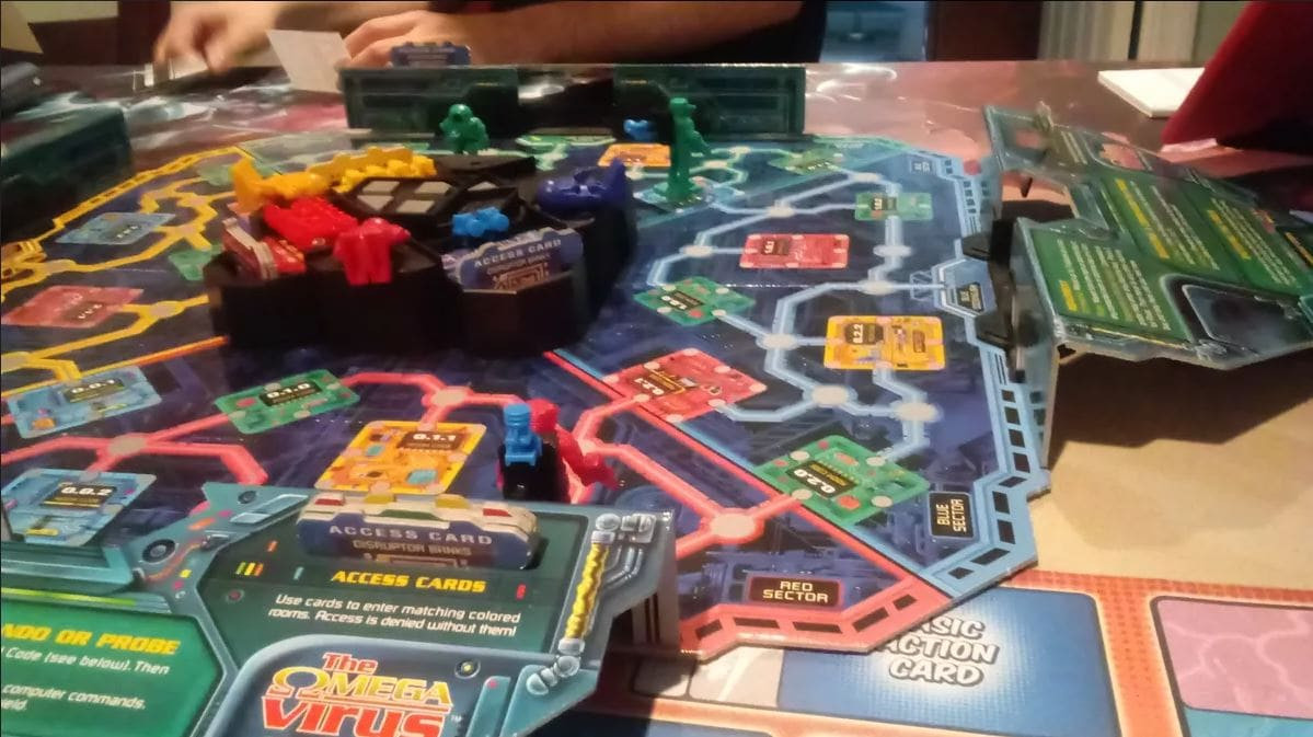 A colorful board setup of the 1990s Omega Virus board game, featuring robots and access cards on a futuristic circuit board layout.