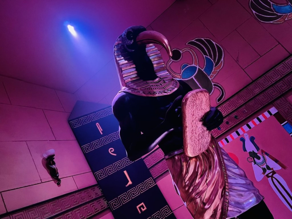 Imposing statue of Thoth in an Egyptian tomb, highlighting the attention to detail in the escape room's set design.