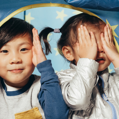 Two kids playing peek a boo game