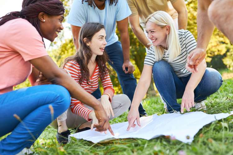 friends looking at map in park for scavenger hunt game