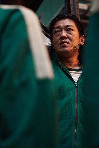 Heo Sung-tae as Jang Deok-su, or player 101, looks angry in a squid game season 1 still
