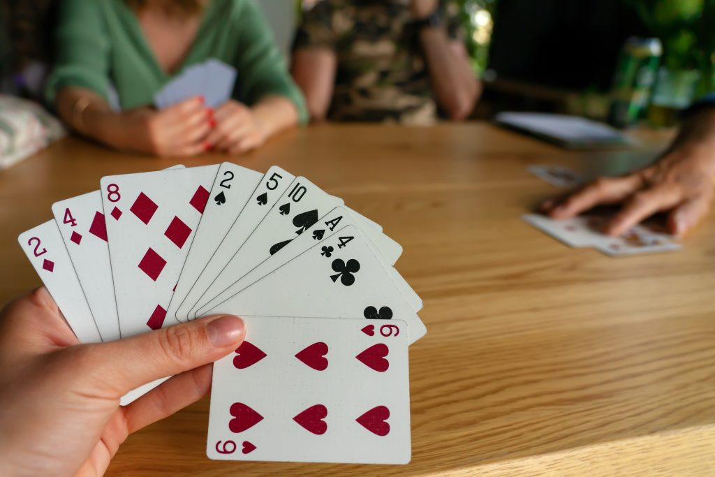 Woman playing cards with friends