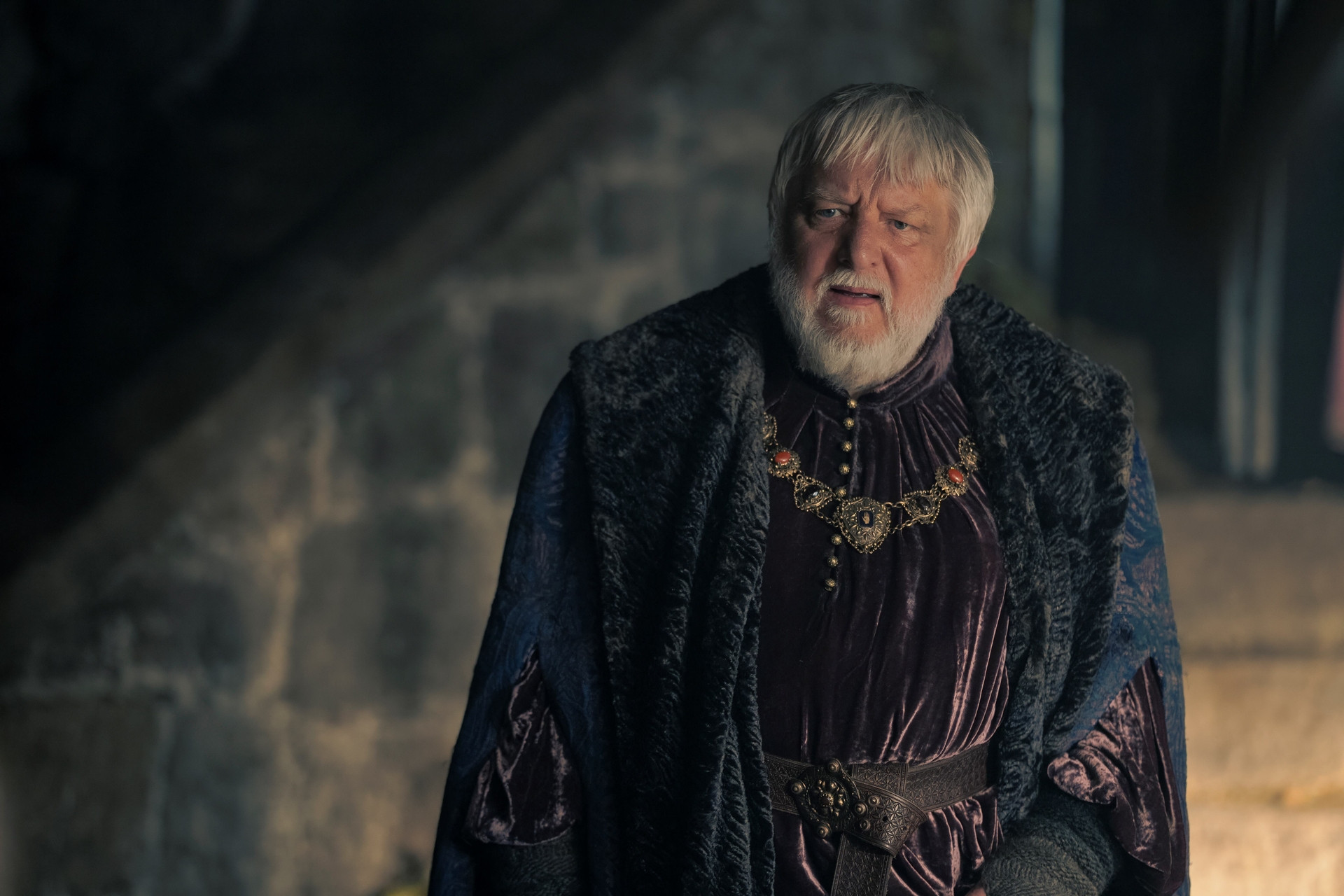 Ser Simon Strong (Sir Simon Beale) looks puzzled in a scene set at Harrenhal in House of the Dragon season 2 episode 4, highlighting his role in the castle's events