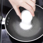 Pouring sugar onto a small skillet for Dalgona candy preparation.