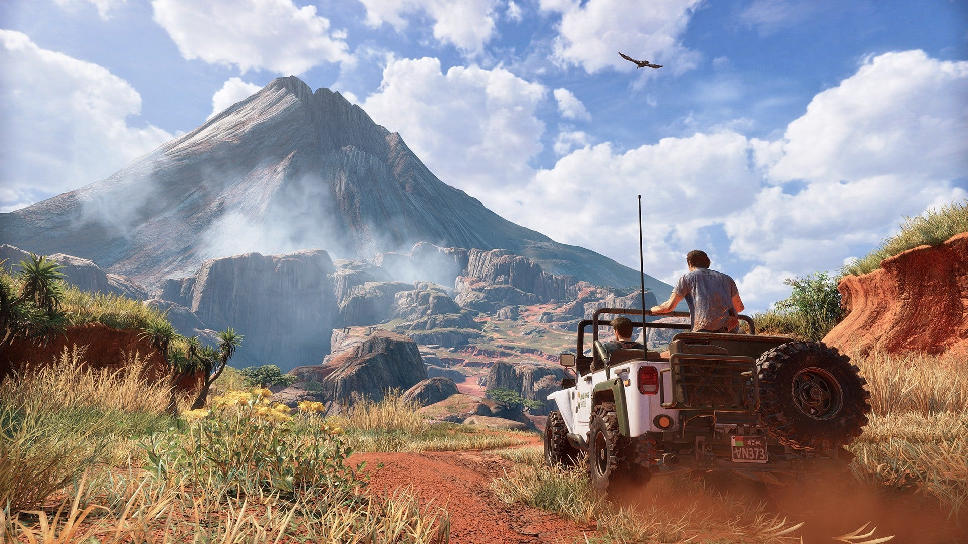 Two characters drive a car toward a volcano
