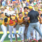 Southeast's Hunter Alexander is mobbed by teammates after his game-winning bunt in the LLWS Championship Game