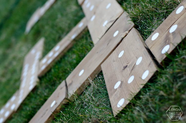 A very large wooden domino game is set up on the grass for outdoor play. 