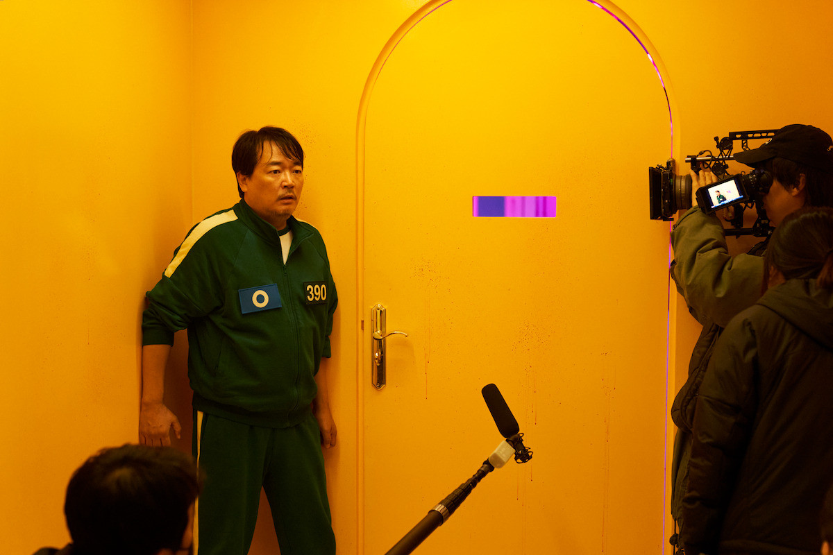 Behind the scenes photo of Lee Seo-hwan as Jung-bae on the set of ‘Squid Game’ Season 2