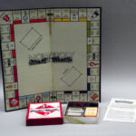 Colour photograph of a Monopoly board showing a smaller box with the cards and houses and hotels