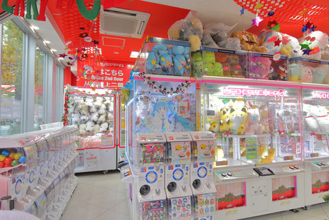 Variety of prizes in a crane game, showcasing plush toys, collectibles, and electronics to attract different player interests