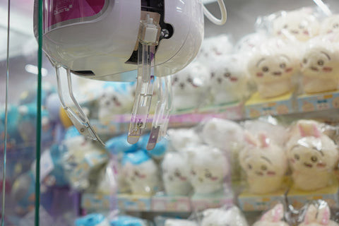 Close-up of a crane claw attempting to grab a prize, highlighting the thrill and anticipation that make crane games addictive