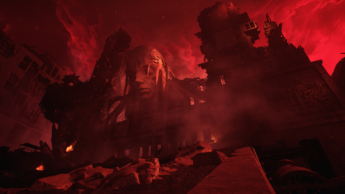 A towering structure erected in the image of an emaciated face under a cloudy, bright red sky in The Forever Winter, highlighting the game's desolate post-apocalyptic atmosphere